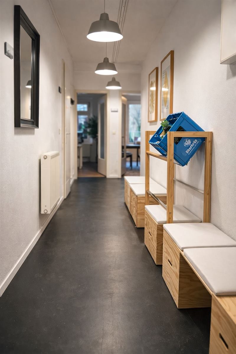 Langer Flur mit Hängelampen, Garderobe und Sitzbänken aus Holz